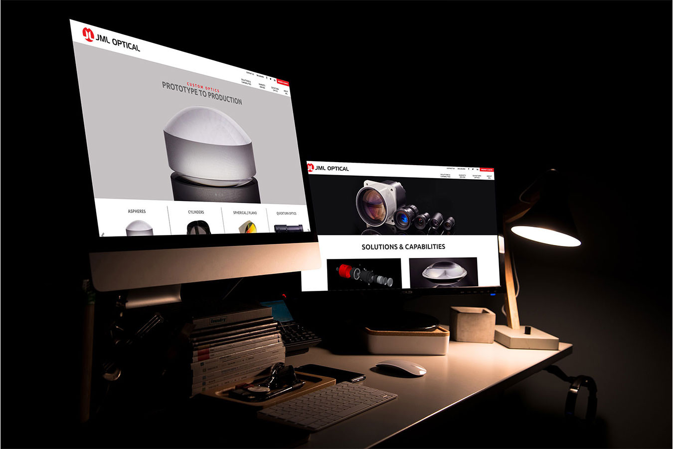JML Optical website displayed on 2 iMacs in a dark room